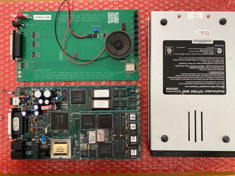 Picture of the bottom of a Hayes Optima 9600 modem and the old and new PCB next to it
